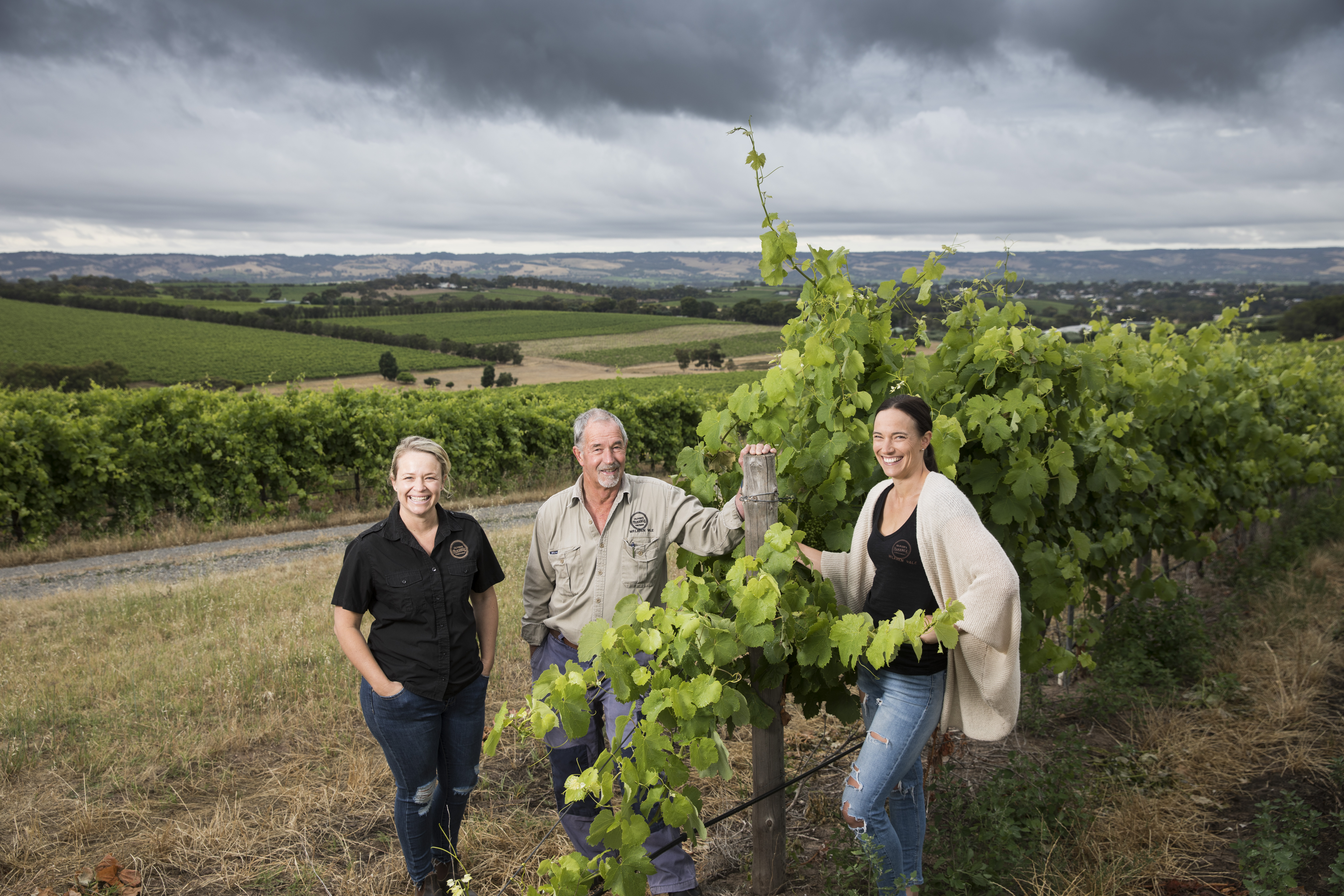 A woman and 2 men at the vineyard 
